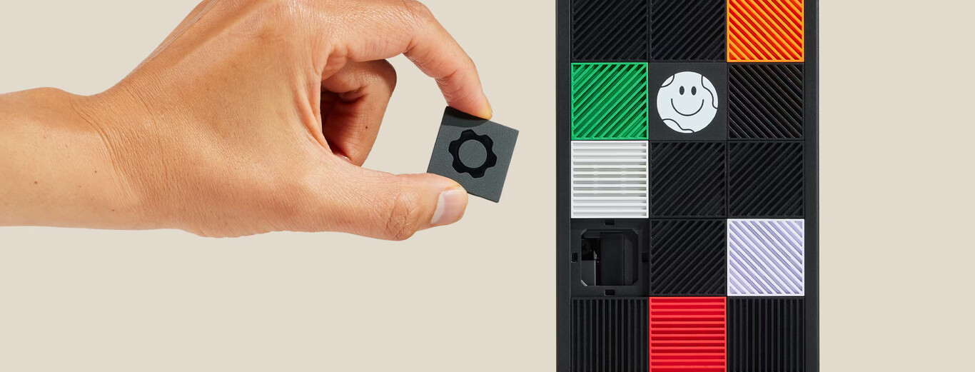 Hand positioning a black square tile with a gear icon to place it into an empty slot on a colorful tile board