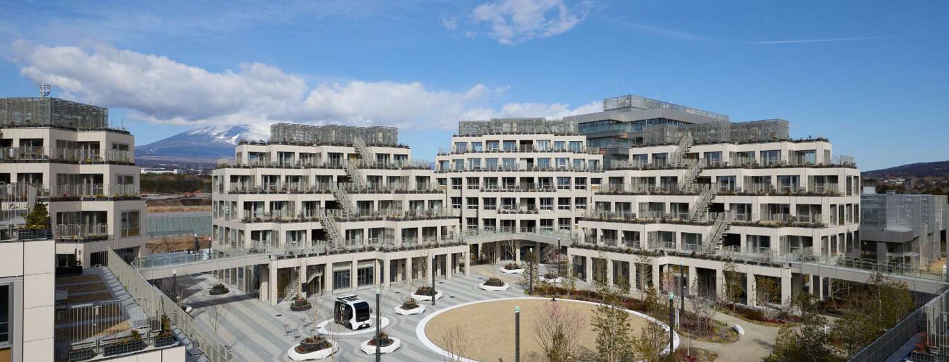Modern residential complex with tiered buildings and central courtyard near Mount Fuji