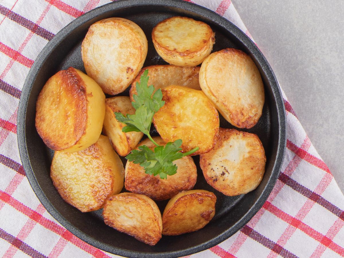 Patatas asadas doradas y crujientes recién sacadas del horno