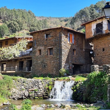 Entre valles y bosques: el pueblo tradicional surcado por una cascada con calles empedradas y casas de piedra