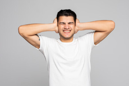 Hombre tapándose los oídos como símbolo de protegerse ante tanto impacto publicitario