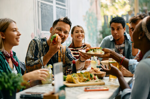 Jovens comendo na mesa. Créditos: Drazen Zigic/GettyImages