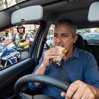 Motorista come sanduíche no volante para não atrasar para o trabalho, é parado pela polícia e acaba multado: entenda o que diz a lei de trânsito 