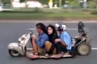 Tres cabezabuques filipinos haciendo el <em>caganer</em> en una Vespa <em>lowrider</em>