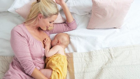 Mamá dando de mamar a su bebé en posicion Acostada De lado