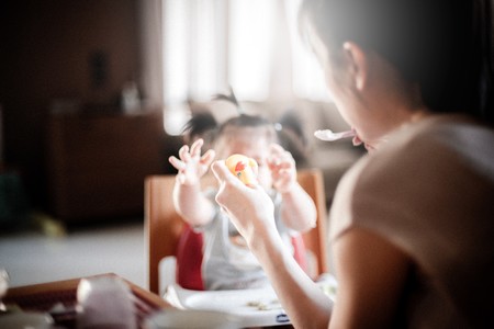 Madre dando de comer a su bebé con cuchara