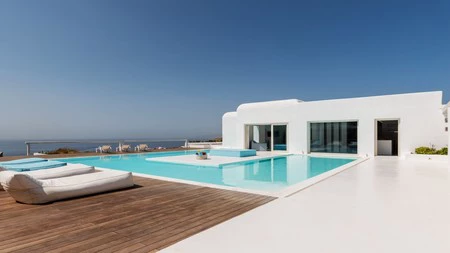Una gran villa en Mykonos en blanco, turquesa y con toques de rojo en el interior, para dar contraste y ritmo a los espacios