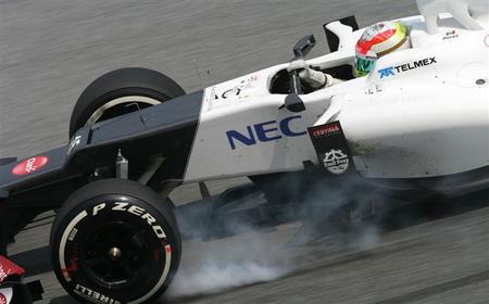 Fernando Alonso acepta el regalo de Sergio Pérez en el Gran Premio de Malasia