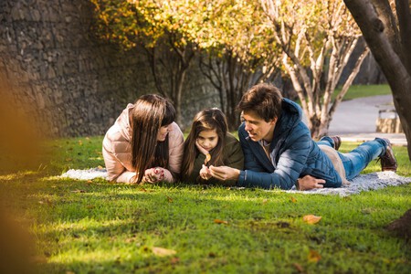 Familia Mirando La Hoja Seca De Otono En El Parque