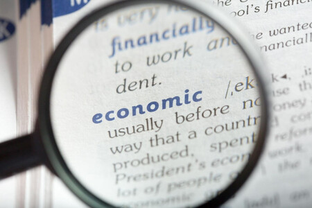 Página de diccionario mirada con lupa, en la palabra economía
