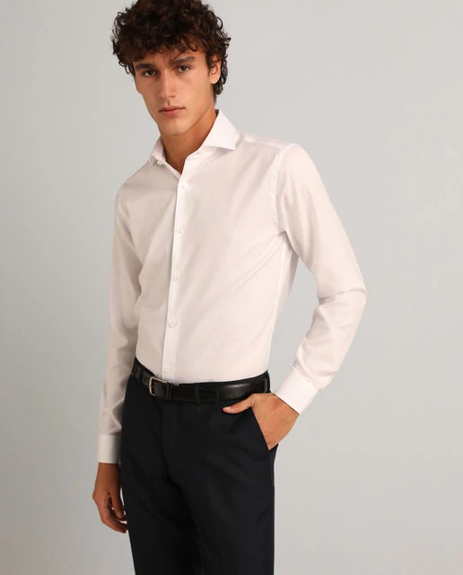 Camisa de vestir slim fit de color blanco lisa. Tiene cuello clásico y puños rectos. Fácil plancha por su acabado especial. Slim Fit Muy entallado, sienta como una segunda piel. Sisa estrecha, ancho de manga ceñido al brazo y contorno ajustado.