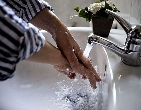 Las Manos Con El Agua De Un Grifo