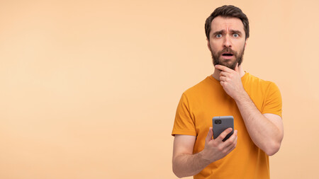 Portrait Young Man Holding Smartphone Looking Concerned