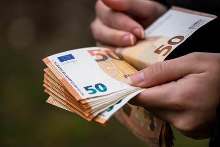 Dos manos cuentan billetes de 50 euros