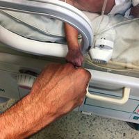 La emotiva imagen de un bebé prematuro y su médico, que transmite en un sencillo gesto la complicidad y lucha por la vida