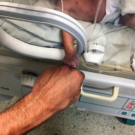 La emotiva imagen de un bebé prematuro y su médico, que transmite en un sencillo gesto la complicidad y lucha por la vida