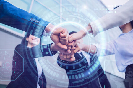 Cuatro personas alargando el brazo y chocando puños, como símbolo de networking