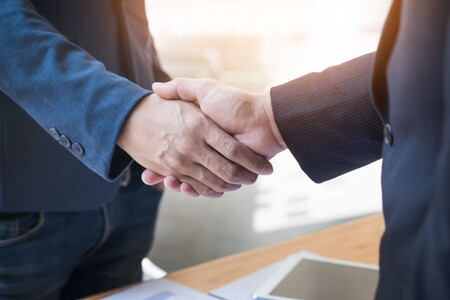 Dos personas dándose la mano, símbolo de negociación exitosa