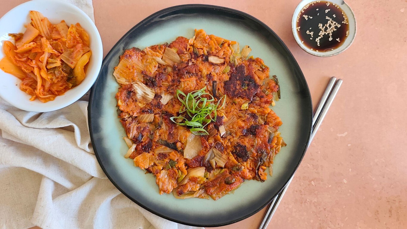 Tortitas de kimchi doradas y crujientes en una sartén con aceite caliente