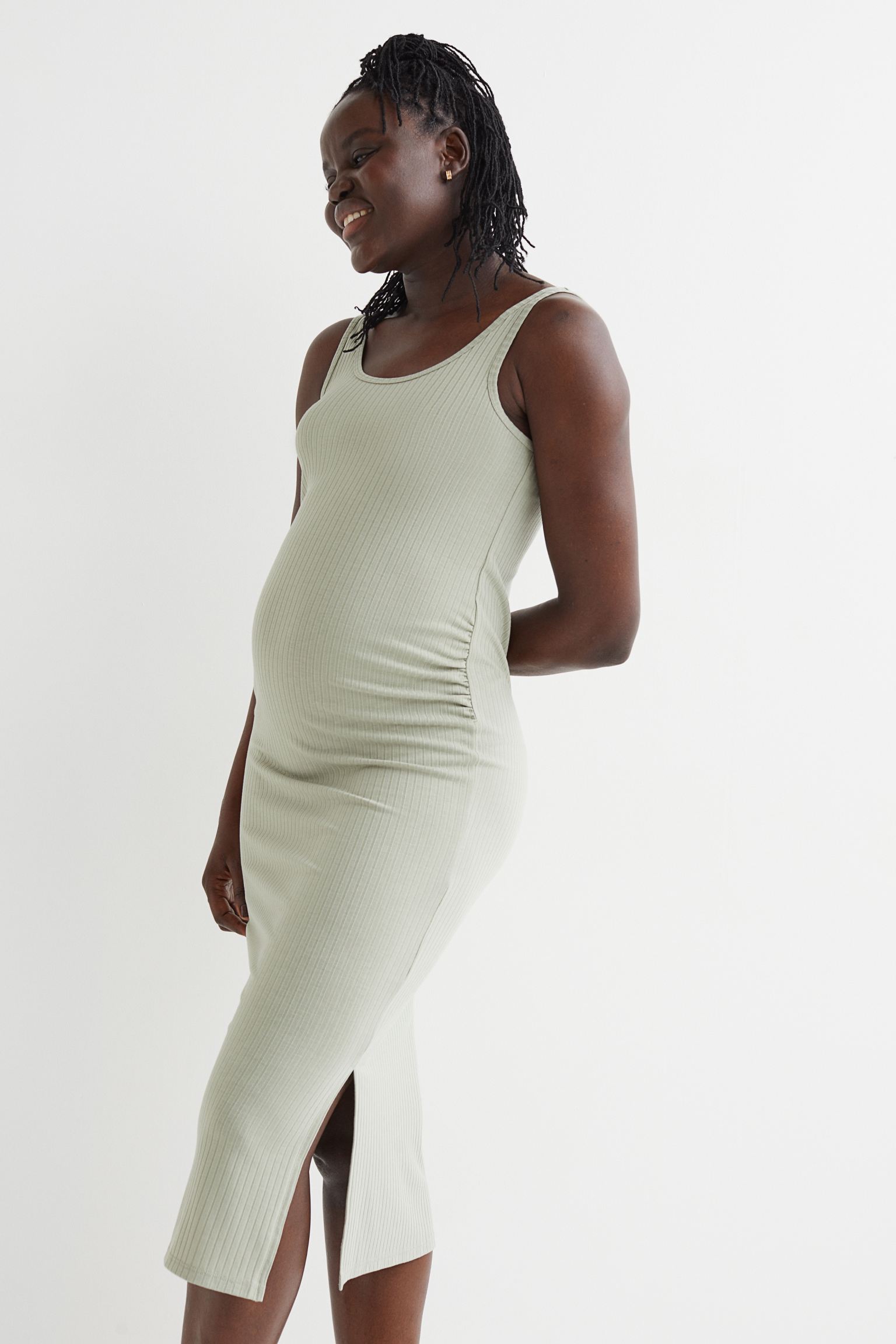 Vestido entallado en punto de canalé con aberturas laterales. Modelo de tirantes con escote amplio y fruncidos laterales para un ajuste óptimo sobre la tripita.