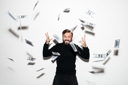 Hombre alegre en medio de una lluvia de dinero