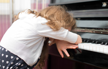 niña cansada de tocar el piano