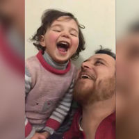 Amor de padre: en medio de un bombardeo, enseña a su hija a reír y así evitar que la pequeña tenga miedo