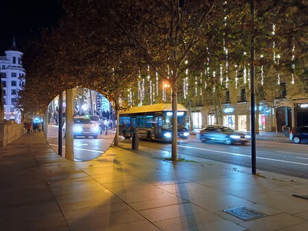 Foto nocturna de una calle de Madrid. En el centro de la imagen aparece un bus en movimiento