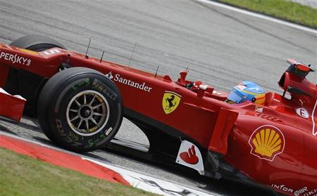 Fernando Alonso acepta el regalo de Sergio Pérez en el Gran Premio de Malasia