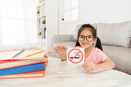 Niña con cartel Prohibido Fumar