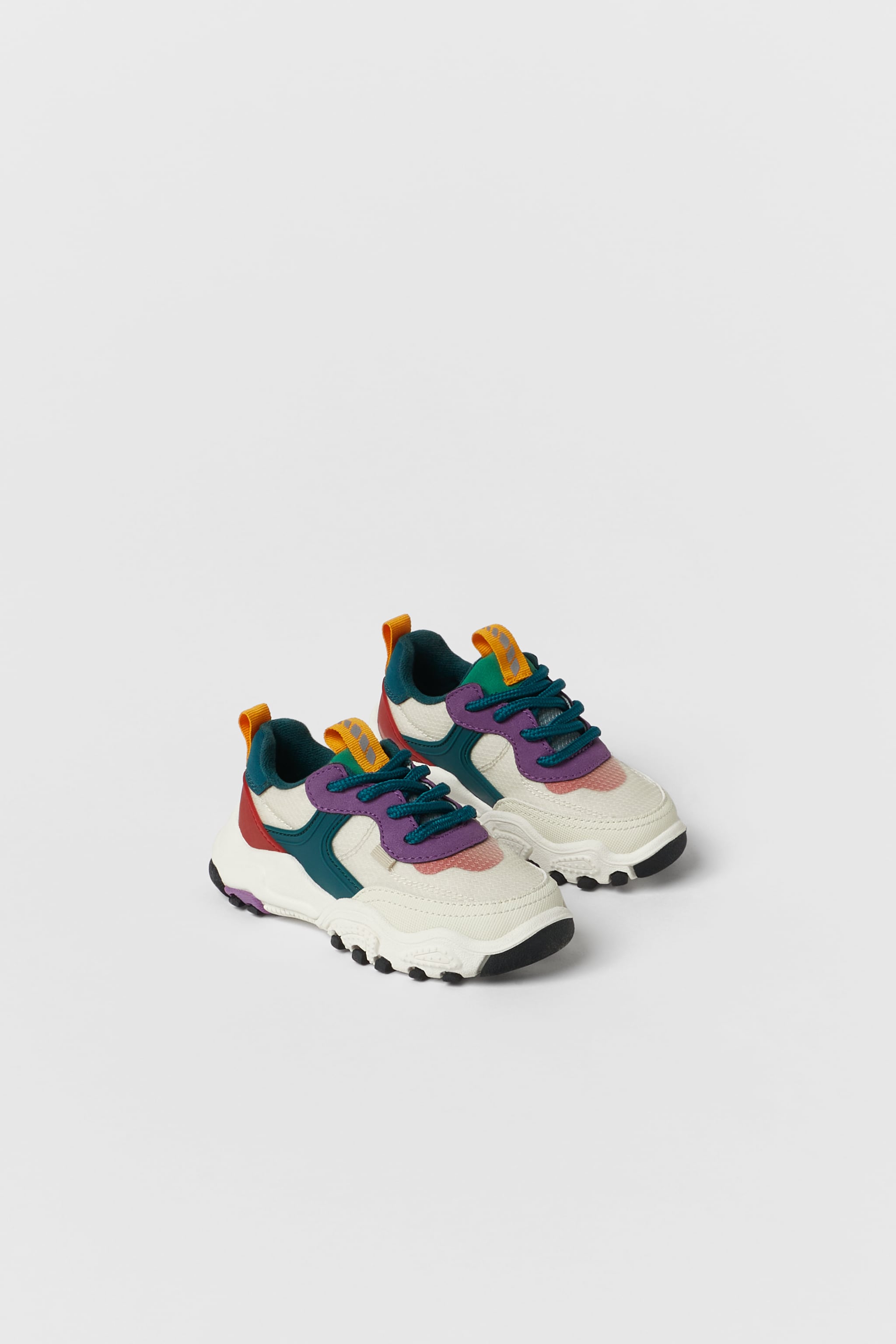 Zapatilla deportiva en combinación de piezas de colores. Cierre mediante cordones.