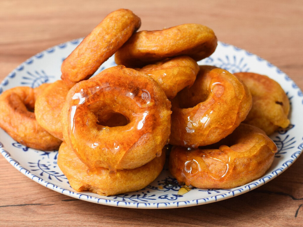 Picarones peruanos, receta tradicional del clásico dulce frito bañados con miel