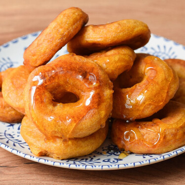 Picarones peruanos, receta tradicional del clásico dulce frito bañados con miel 