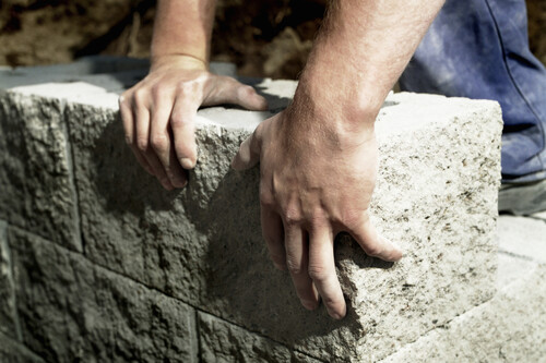mãos humanas tocando em estrutura de concreto