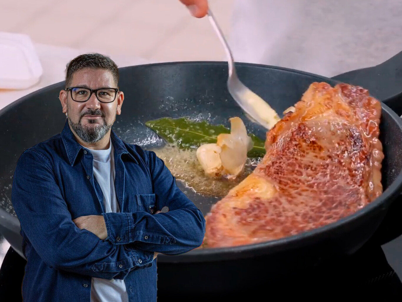 Entrecot siendo cocinado en sartén con mantequilla y aceite de oliva vertidos sobre la carne