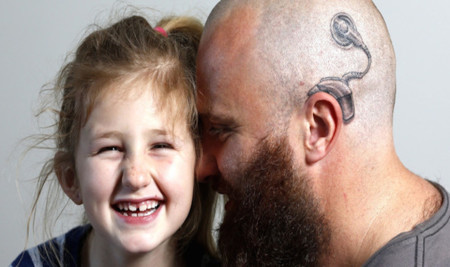 Un padre se tatúa un implante en la cabeza como muestra de apoyo a su hija sorda