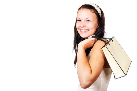 Chica con bolsa de compra sonriendo.