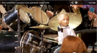 Niño ruso de tres años toca la batería en una orquesta