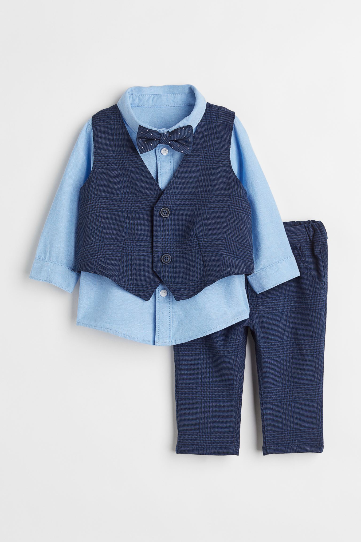 Conjunto de pantalón y chaleco estampados, y camisa de manga larga con pajarita.