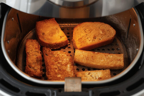 Una Airfryer Con Tostadas Y Barritas De Pan Dentro Descongelandose En Horizontal