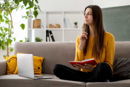 Mujer pensando mientras escribe. Los sesgos cognitivos afectan al pensamiento y las decisiones, volviéndolos irracionales en ocasiones