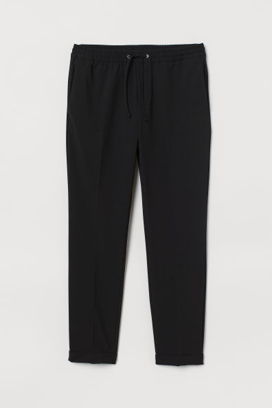 Joggers tobilleros de tela. Modelo con cintura elástica con cordón de ajuste, bolsillos al bies diagonales, bolsillos traseros insertados, perneras con raya y bajos vueltos cosidos. Corte ajustado – modelo entallado en muslo, rodilla y tobillo para una silueta depurada.